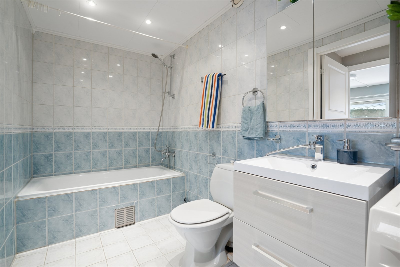 Badet er innredet med en servantseksjon, toalett og et badekar. Galleribilde