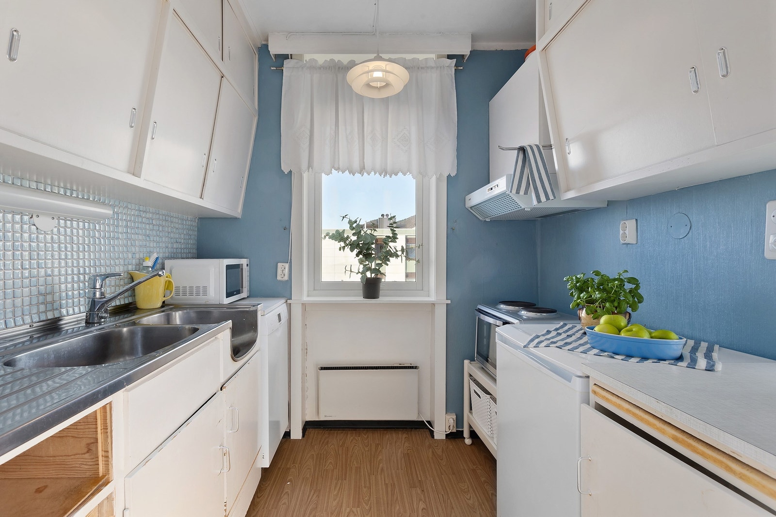 Eldre kjøkkeninnredning med frittstående hvitevarer Galleribilde