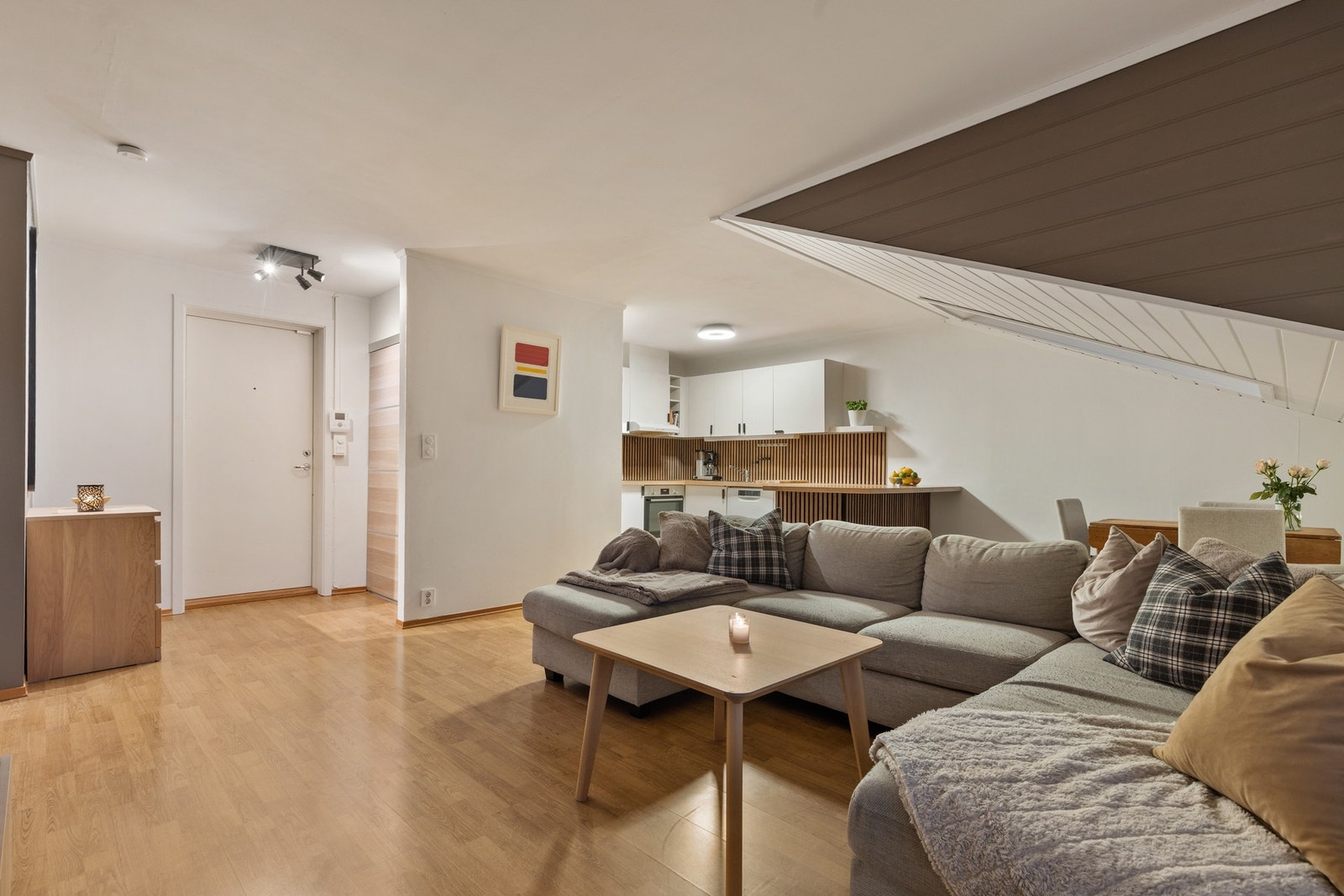 Rommet har åpen kjøkkenløsning og fin plass til sofa, tv-møblement og spisebord Galleribilde