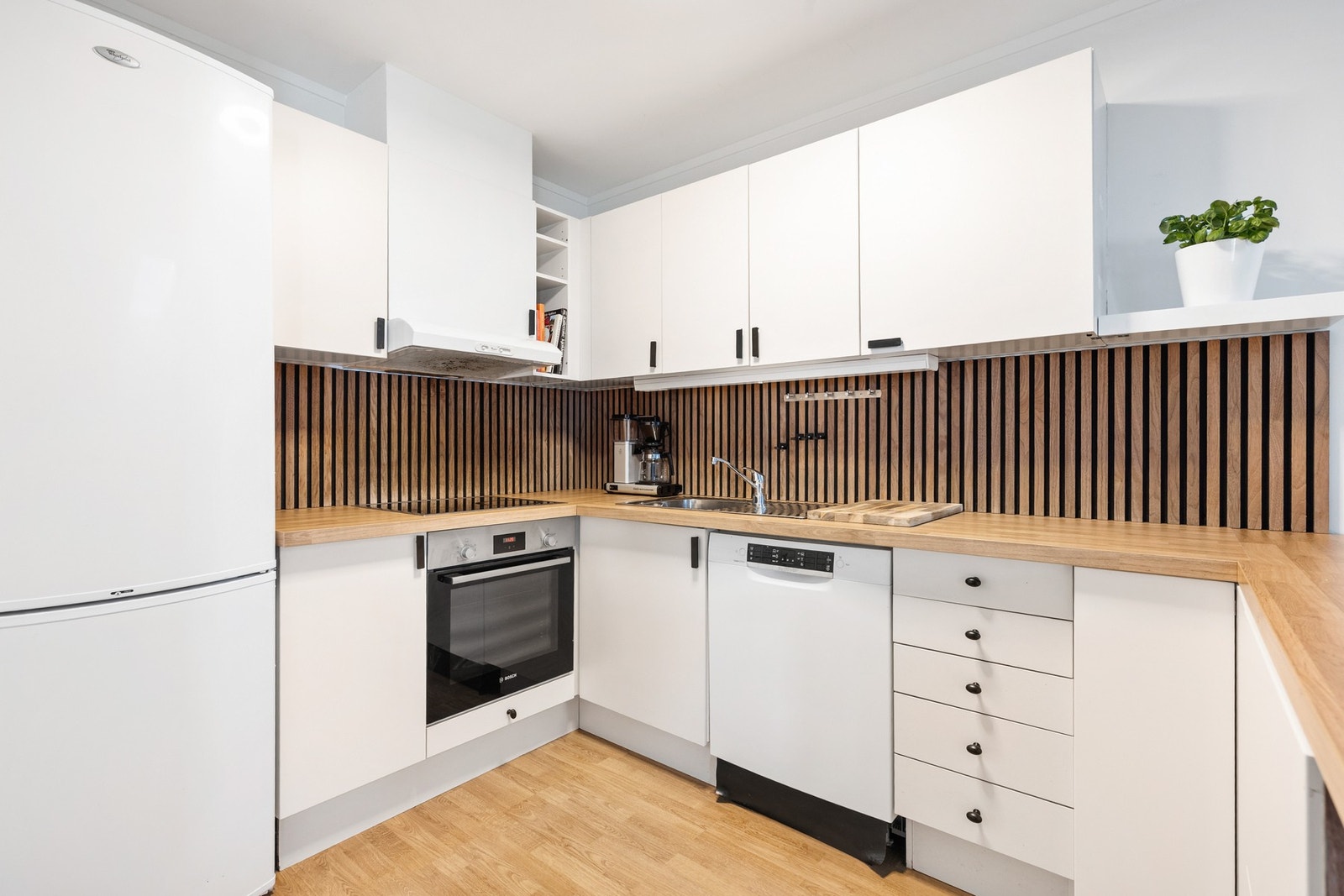 Innredningen har platetopp, stekeovn og nisjer til oppvaskmaskin og kjøl/fryseskap Galleribilde