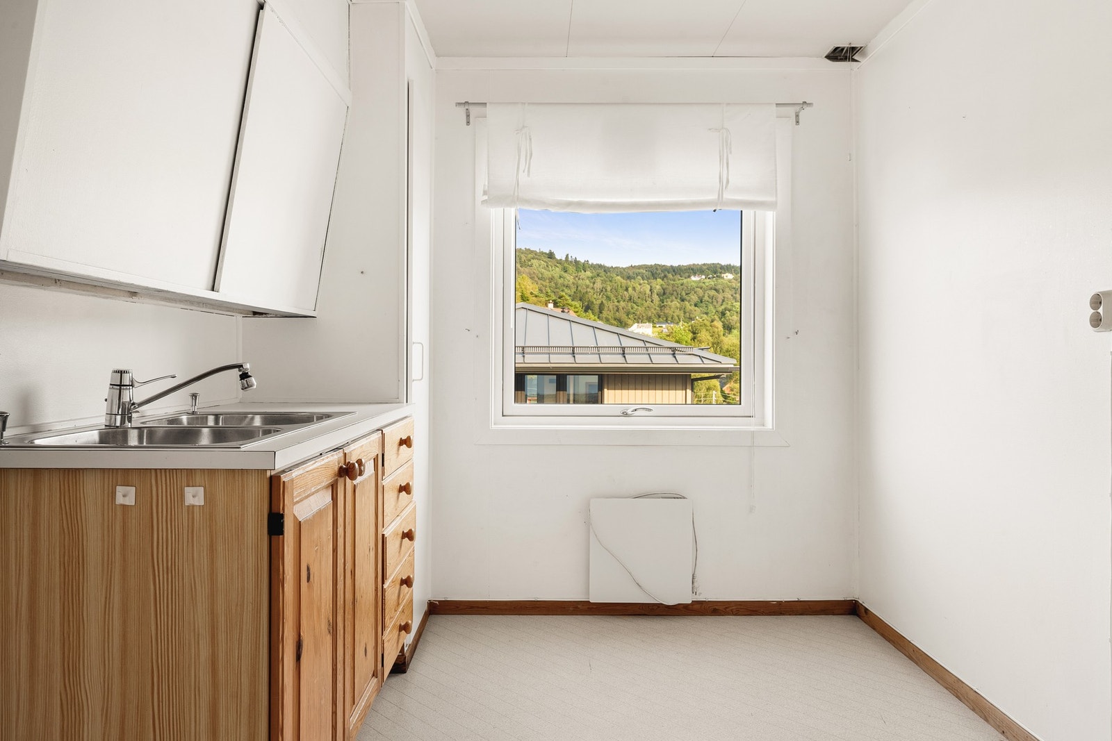 Kjøkkenet har enkel innredning og fremstår som et rom modent for oppgradering. Galleribilde