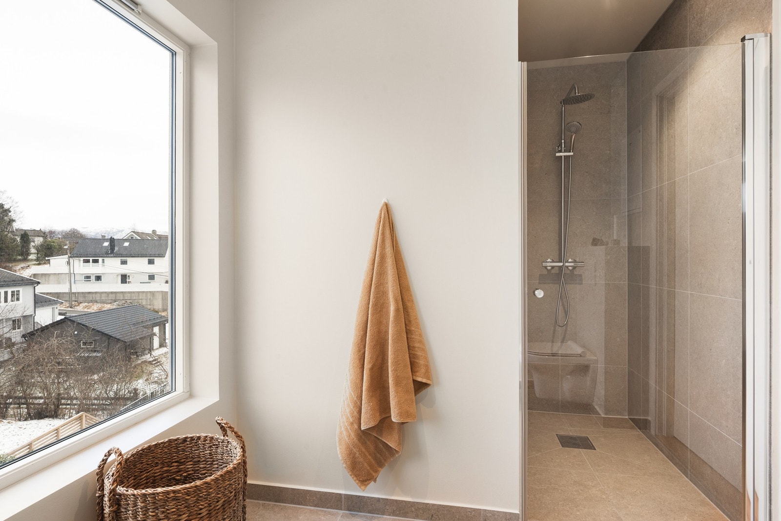 Rommet har fliser på gulv og i dusjsone, malte, slette vegger og downlights i tak. Galleribilde