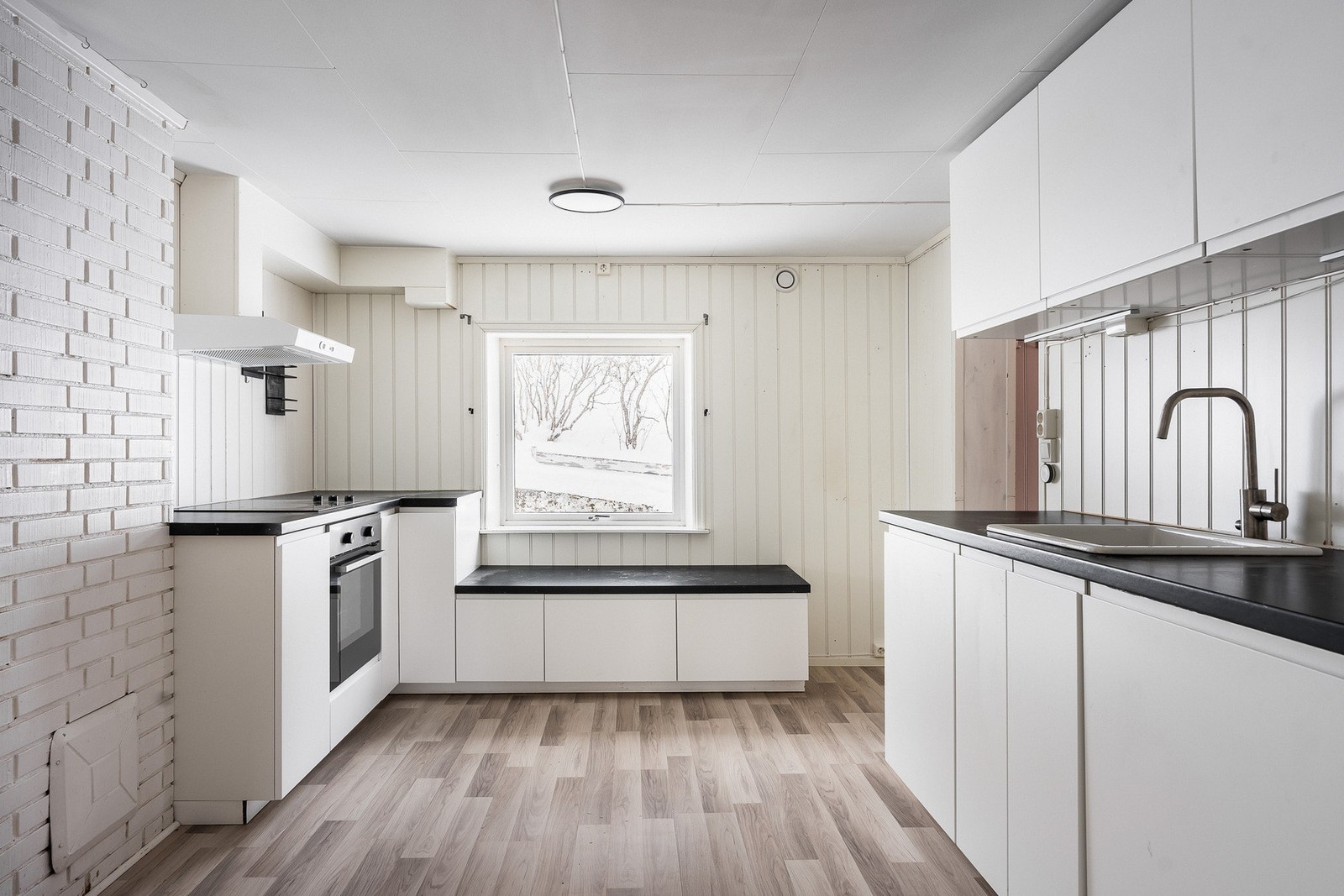 Under vinduet er det en koselig sittebenk med sokkelskuffer. Integrert i innredningen finner man platetopp, stekeovn og oppvaskmaskin. Over kokesonen er en ventilator etablert med avtrekk. Galleribilde