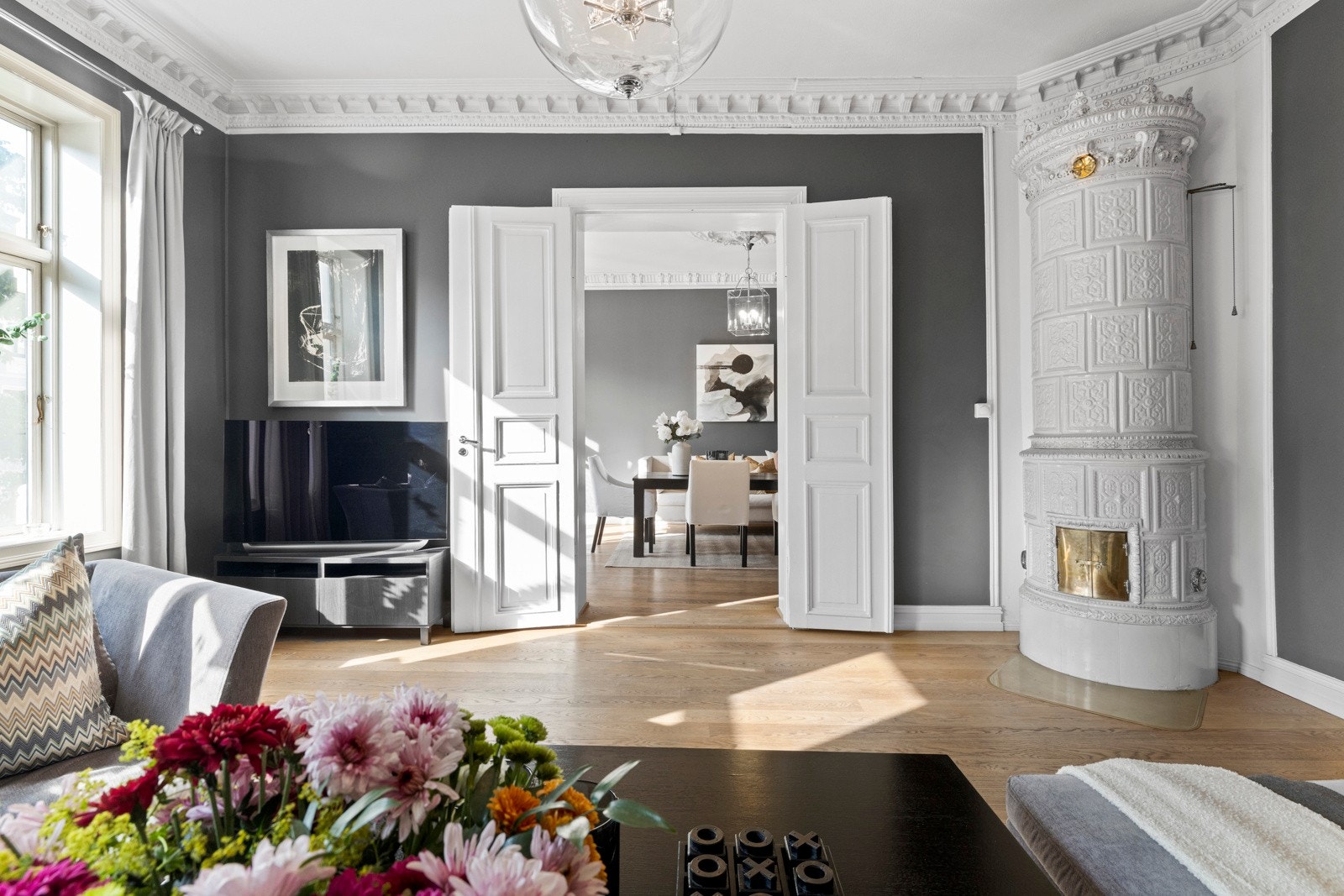 Stuen er romslig og gjennomgående, med vakre detaljer som stukkatur, gipsrosett og en klassisk kakkelovn som tilfører både varme og sjel. Galleribilde