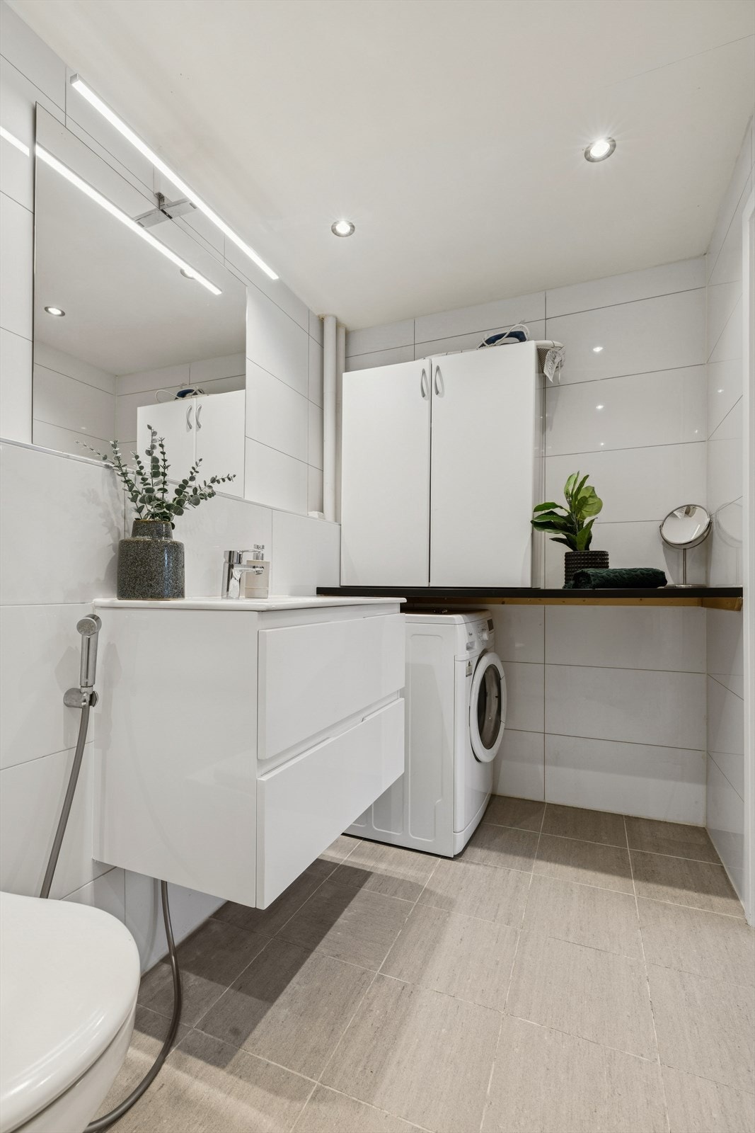 Det er opplegg og plass for vaskemaskin under praktisk laminert benkeplate, samt overskap for ekstra oppbevaring. Galleribilde