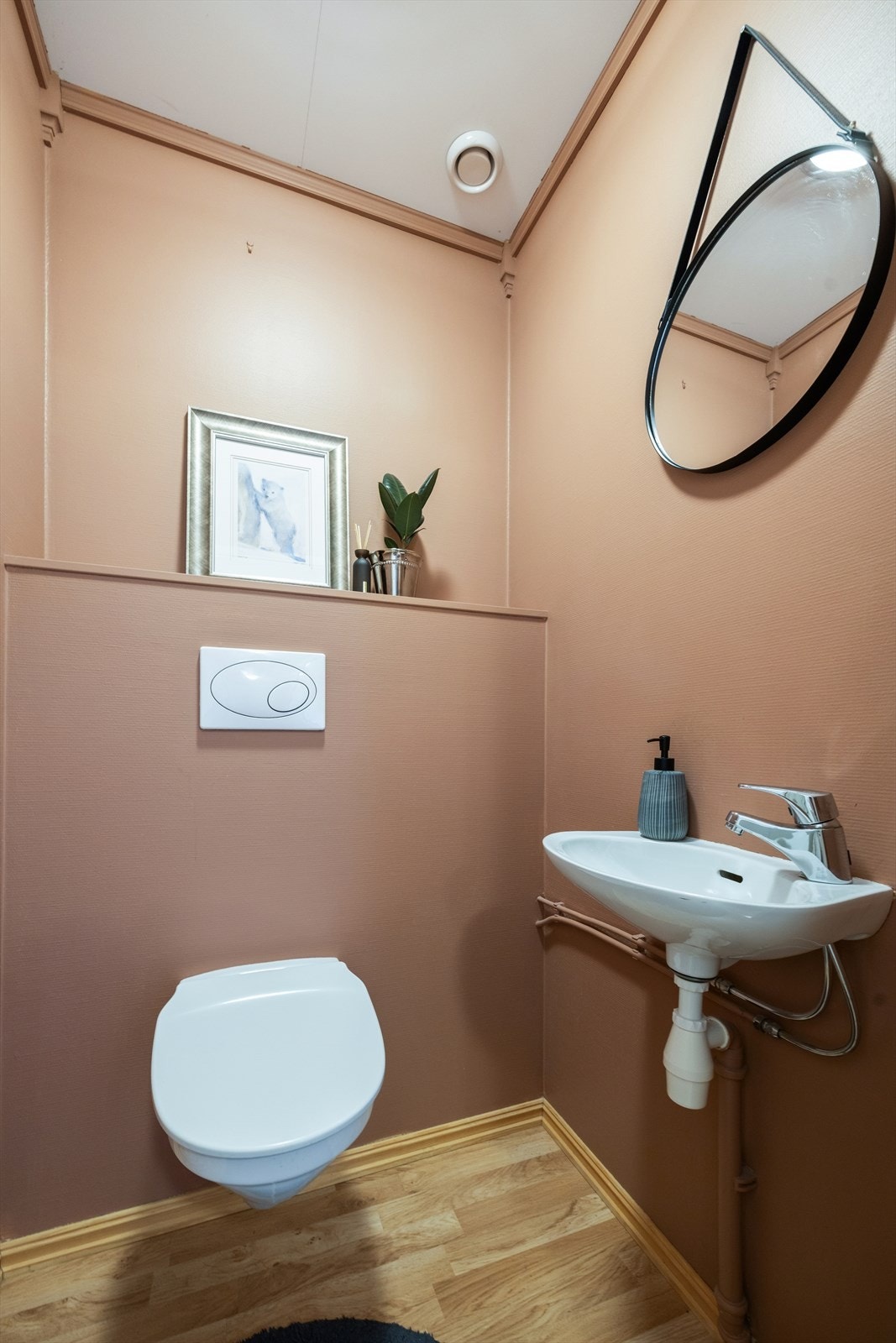 Lyst toalettrom utstyrt med vegghengt toalett og servant. Galleribilde