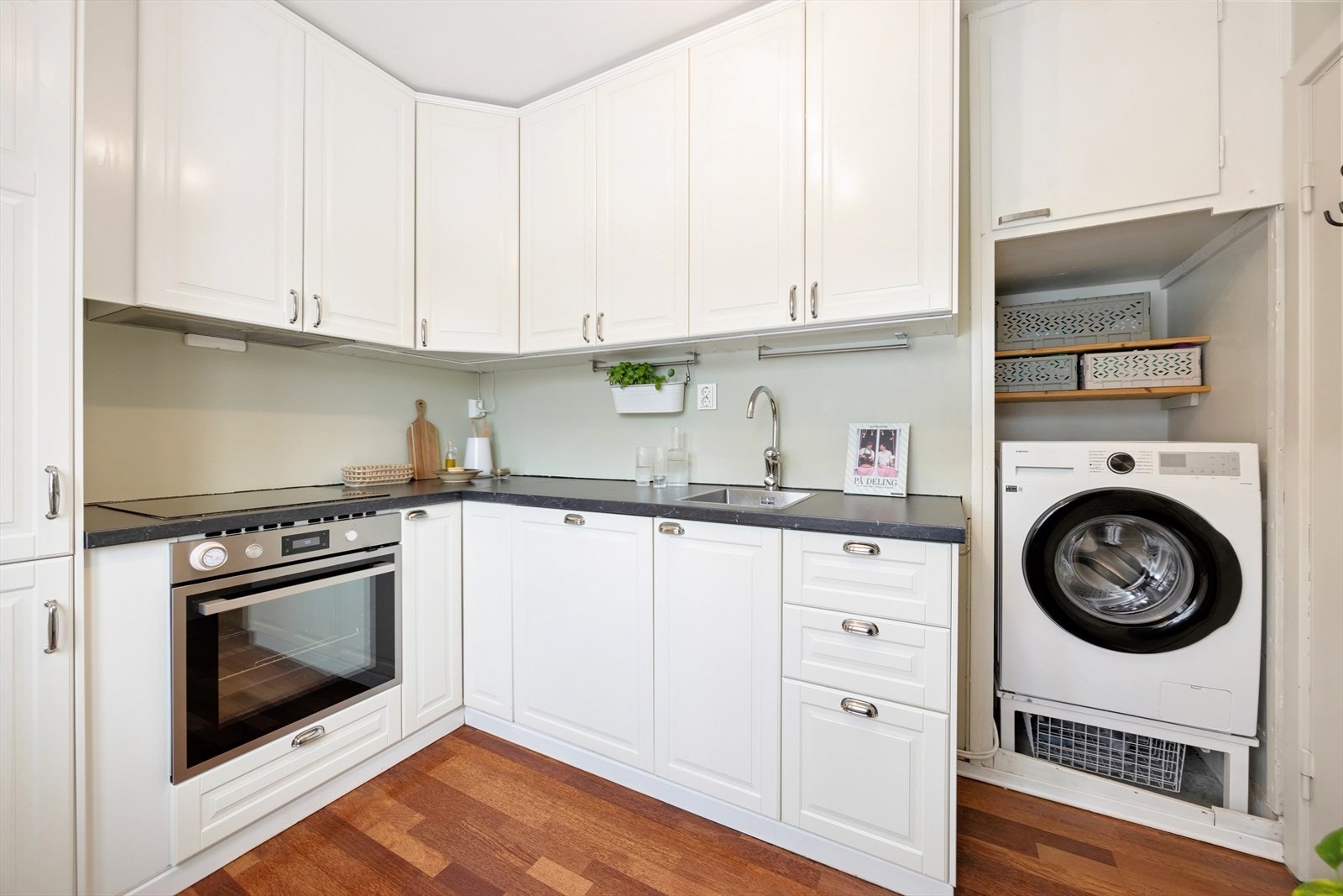 Kjøkkenet har innredning med profilerte fronter, med opplegg for vaskemaskin Galleribilde