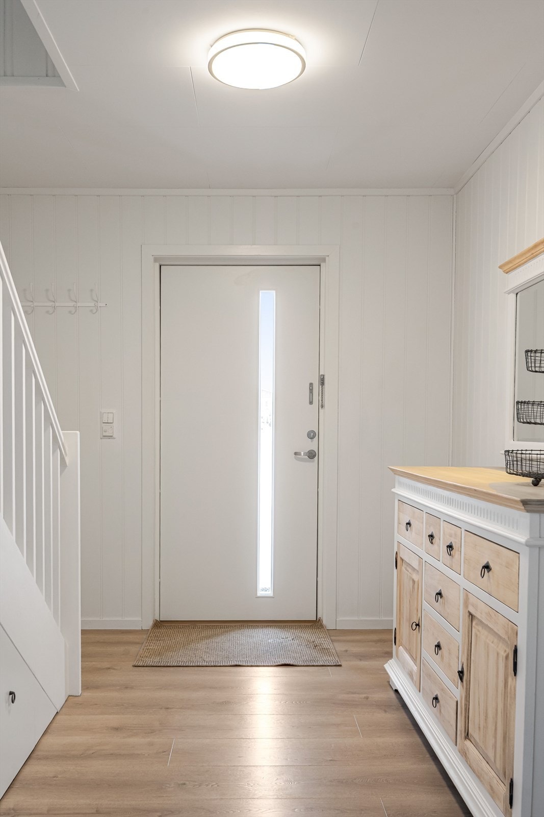 Du møtes en lys entré med pent laminatgulv med varmekabler og hvite MPF-plater på veggene. Galleribilde