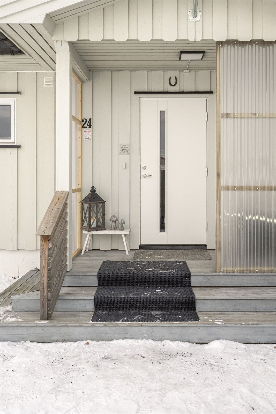 Inngangsparti med takoverbygg og tretrapp med levegger. Entrédøren har isolerglass. Galleribilde