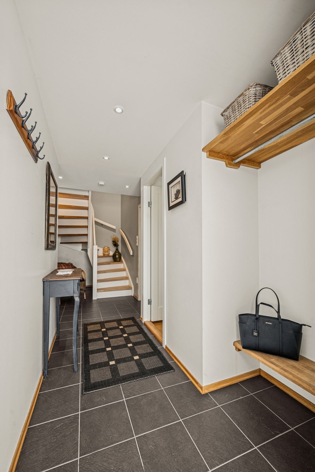 Man ønskes velkommen inn i en romslig entré gang. Flislagt gulv med varmekabel. Downligts i tak. Galleribilde