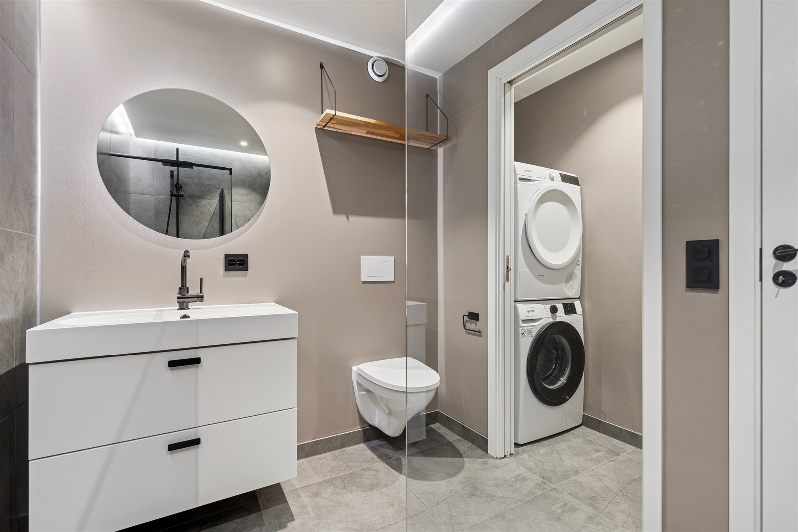 Skyvedør mellom bad og innhukket gjør det enkelt å skjule vaskemaskin og tørketrommel. Disse medfølger handelen. Galleribilde