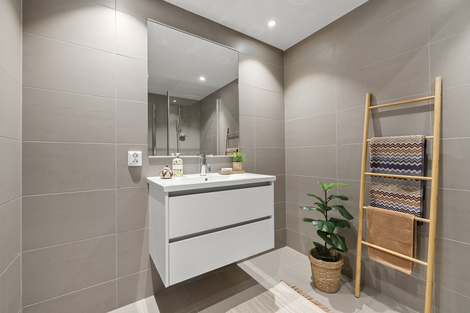 Baderomsinnredningen består av en heldekkende servant med skuffer og et stort speil. Galleribilde