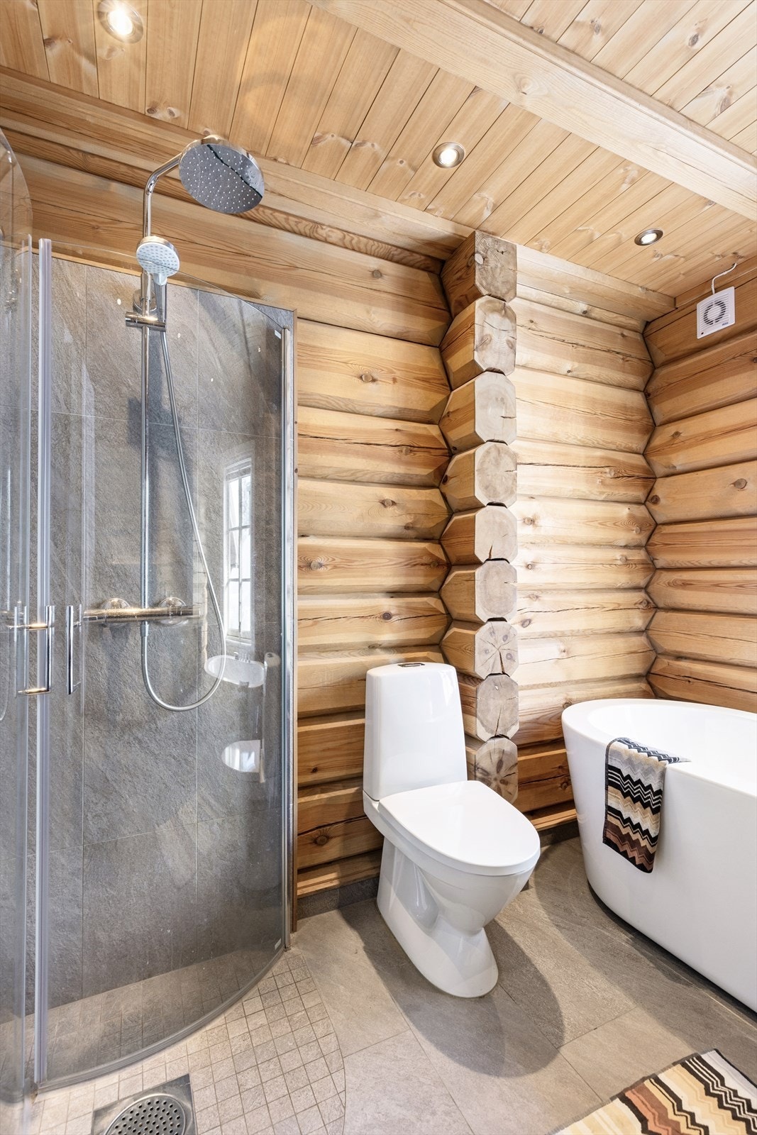 Badet har bederomsinnredning med servant, badekar, dusjhjørne med glassdører og toalett. Galleribilde