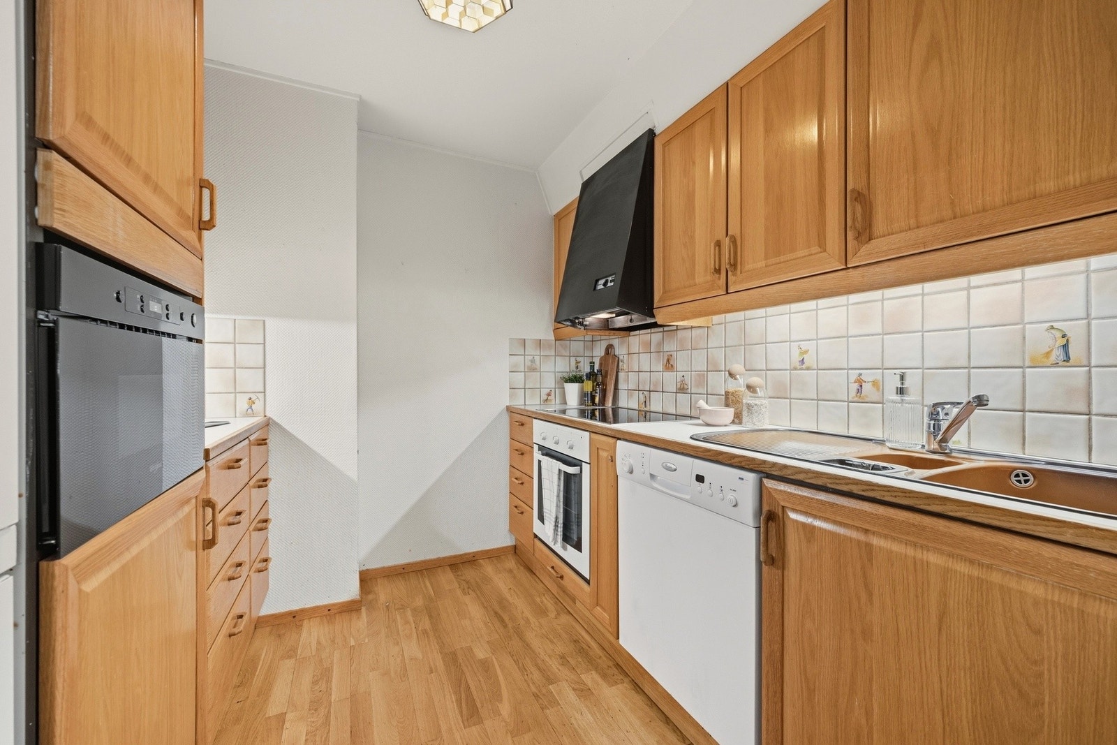 Innholdsrikt kjøkken med gode oppbevaringsmuligheter i over- og underskap Galleribilde