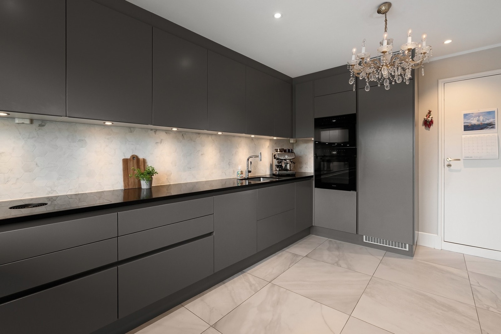 Kjøkkenet er utstyrt med hvitevarer av høy kvalitet. Planlimt platetopp fra BORA med integrert ventilasjon. Øvrige hvitevarer fra Miele, blant annet både stekeovn og kombiovn. Kjøkkenet har italienske marmorfliser med varme i gulvet. Galleribilde