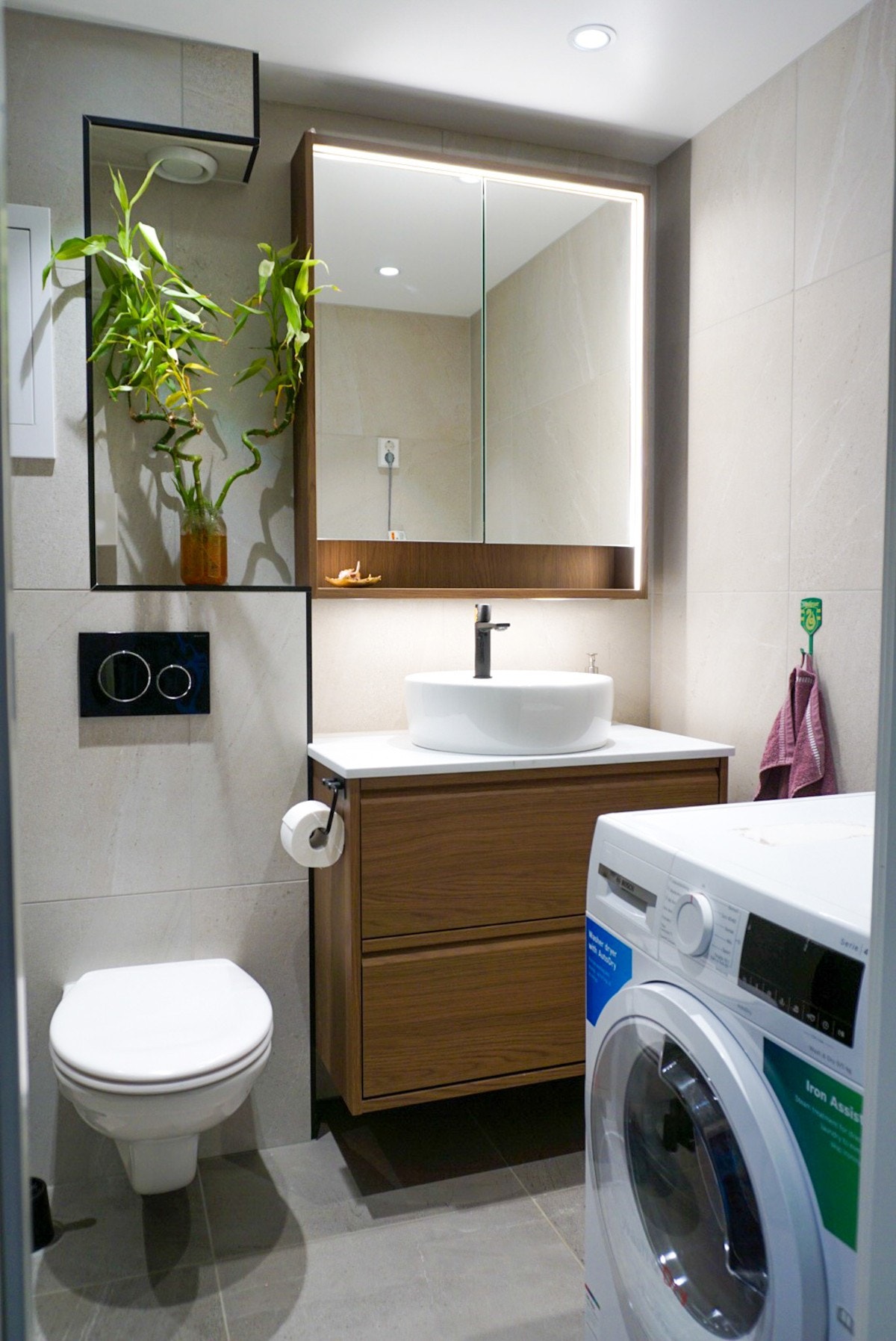 Leilighetens baderom har flislagte vegger og gulv med behagelige varmekabler. Innredningen består av servant med underskap, vegghengt toalett, opplegg til vaskemaskin og dusjhjørne. Galleribilde