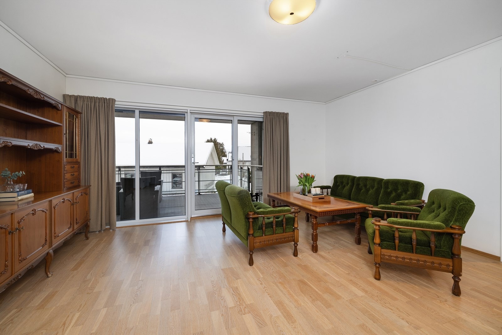 En stor skyvedør i tre med glassfelt åpner opp mot terrassen og slipper inn lys. Galleribilde