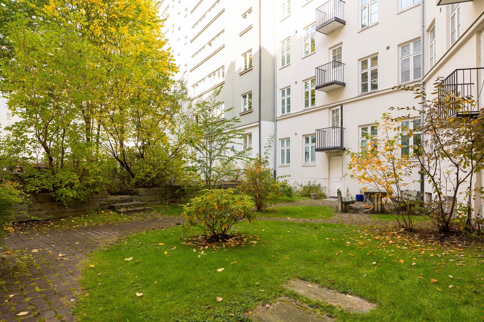 Bakgården har plenareal, trær og planter. Galleribilde