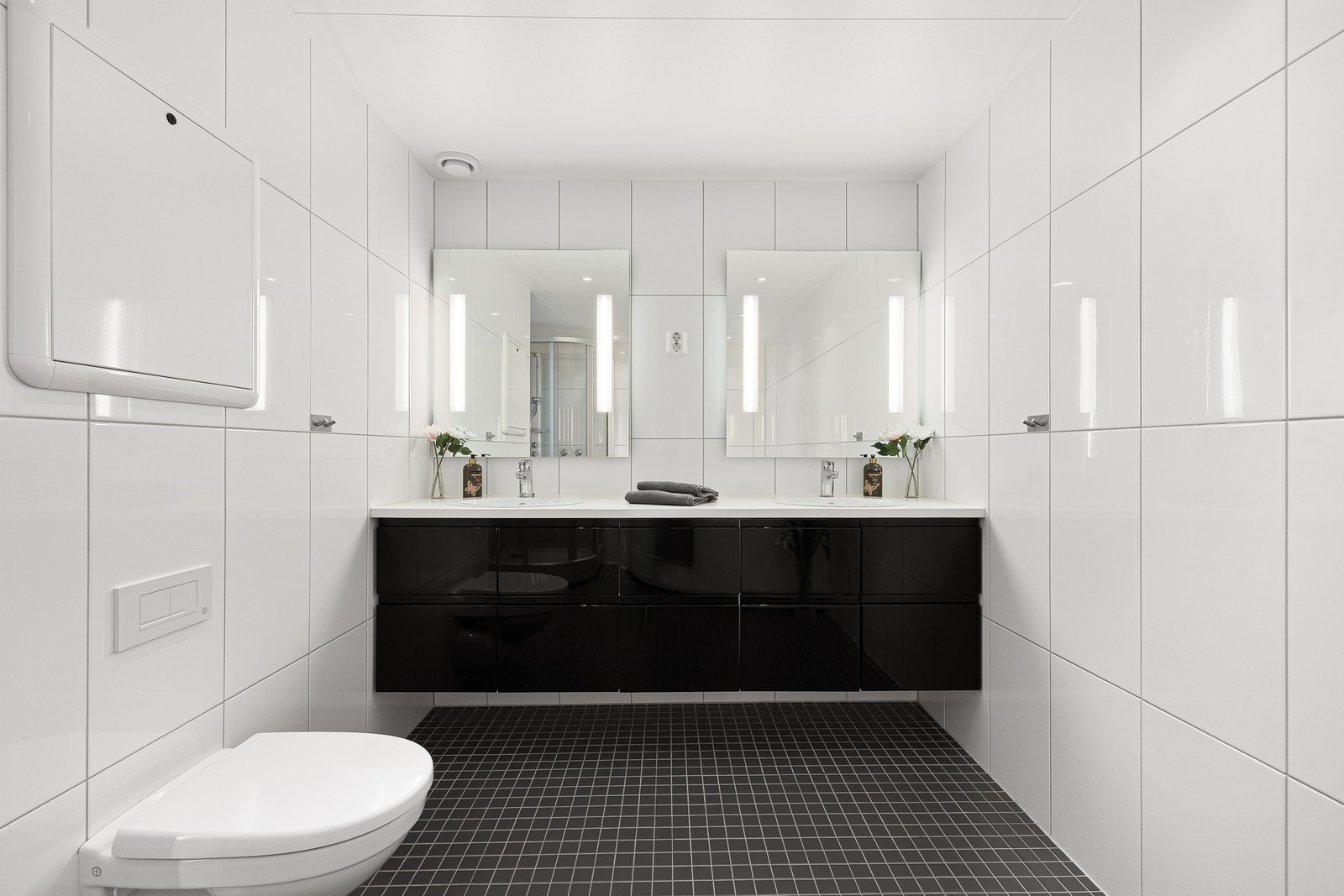 Det flislagte badet er på 8,5m² og har bl.a veggmontert WC, servantplate med to servantskåler og to veggmonterte speil med belysning. Galleribilde