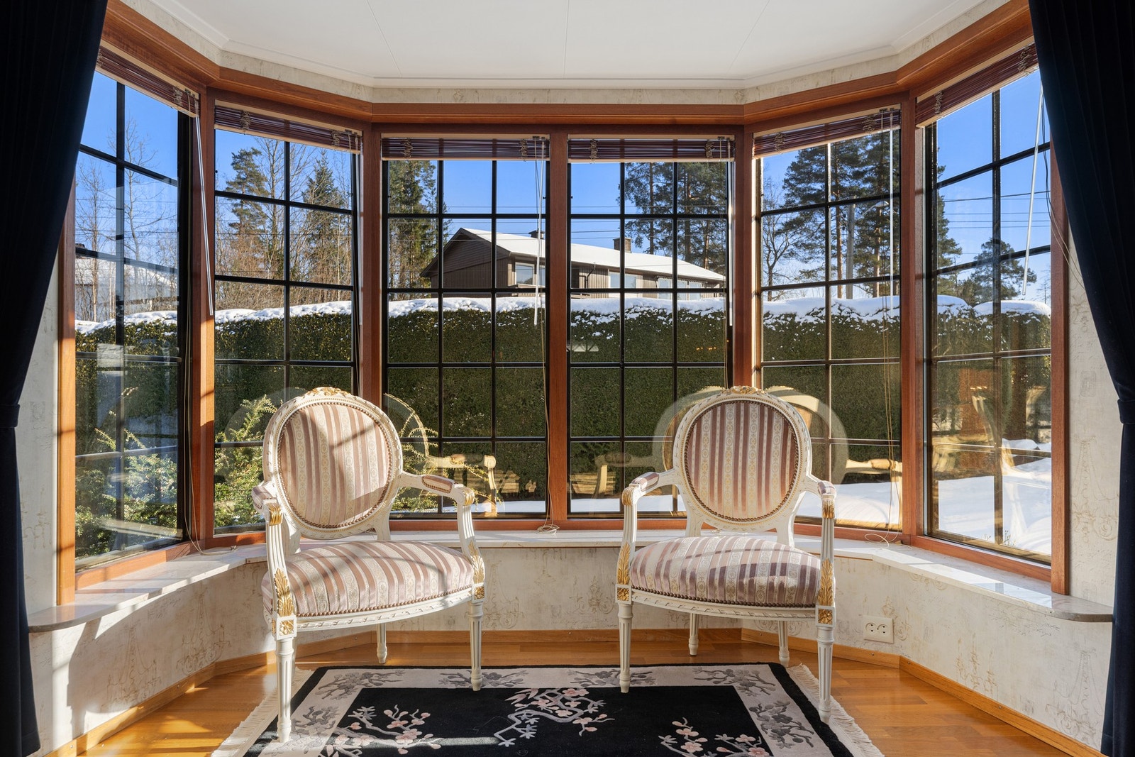 Den flotte karnapp-løsningen skaper en stemningsfull sitteplass med utsyn mot hagen. Galleribilde