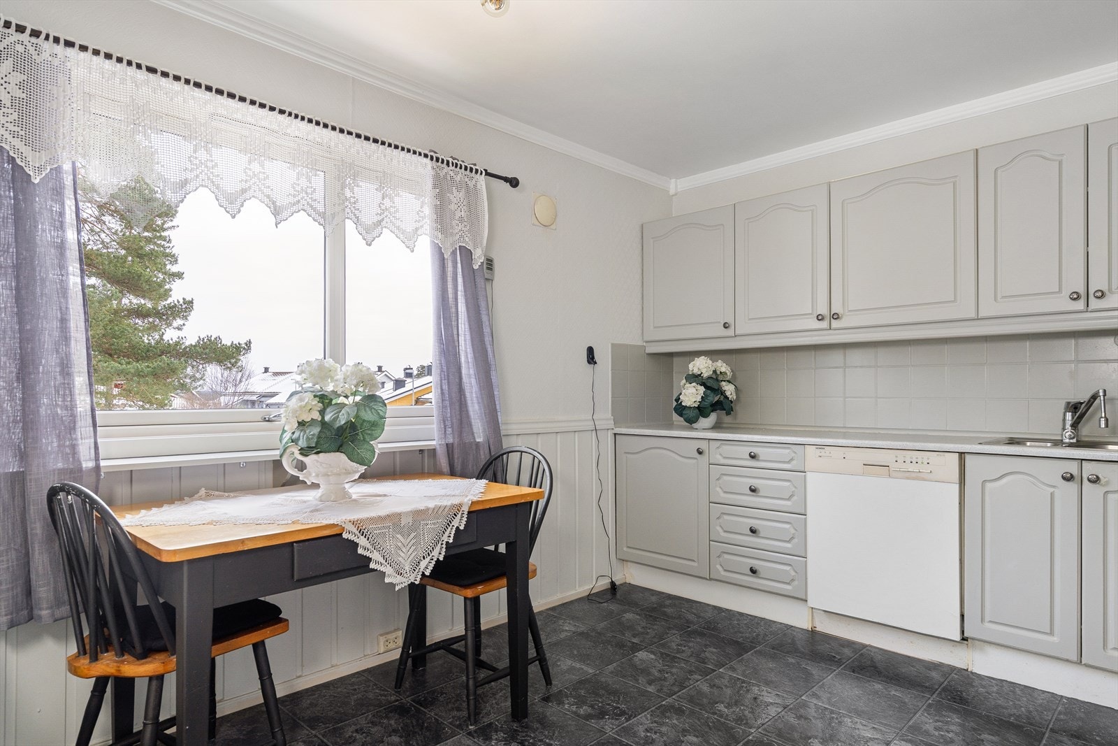 Kjøkken med vindu mot øst hvor morgensolen skinner inn. Plass til enkelt spisebord. Galleribilde