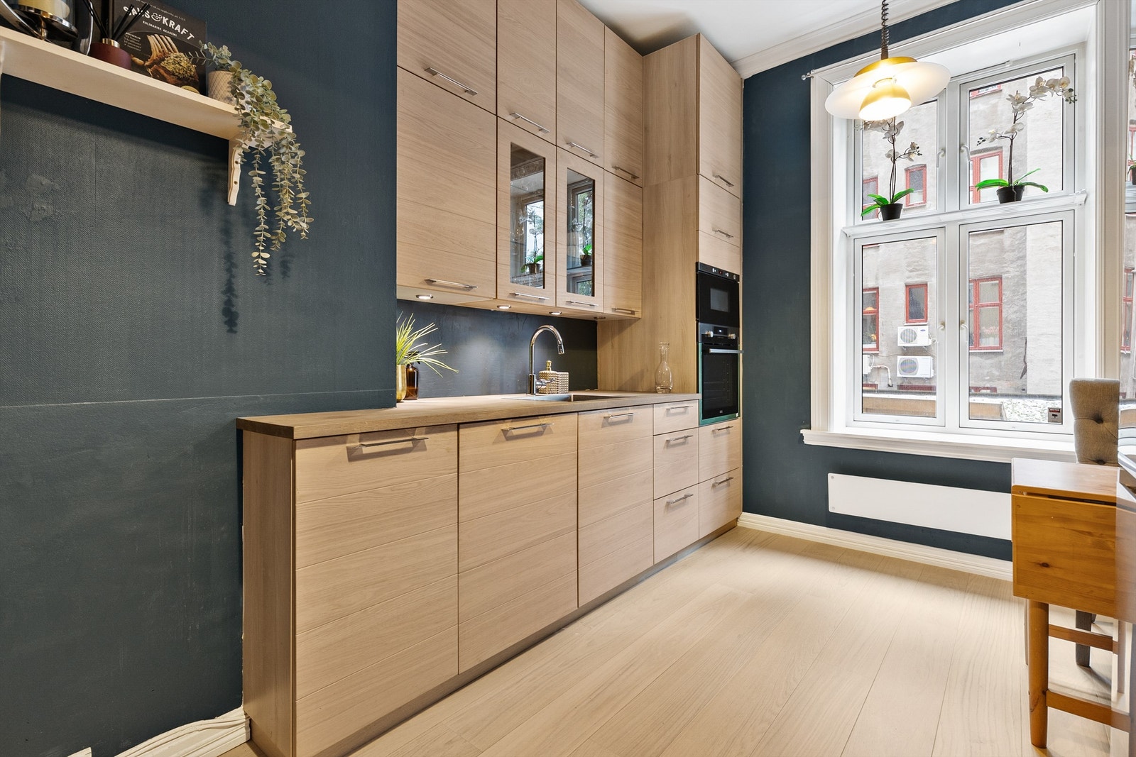 Kjøkkeninnredning med slette fronter i tre, integrert stekeovn og god skapplass. Galleribilde