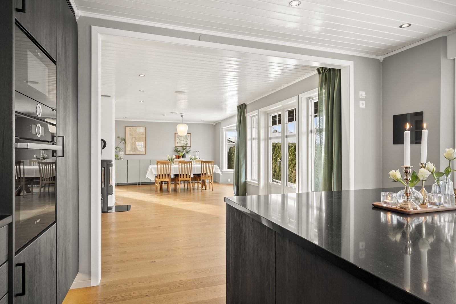 Stilrent kjøkken med grå, slette fronter og granittbenkeplater. Galleribilde