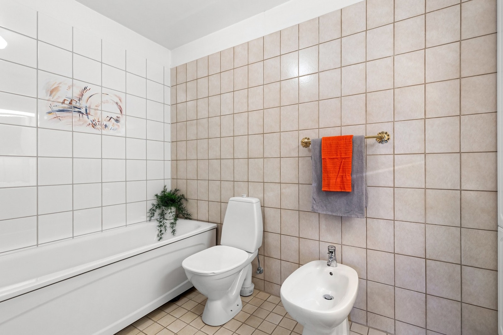 Stort bad med dusj, badekar, wc, bidet og servant med over- og underskap. Galleribilde