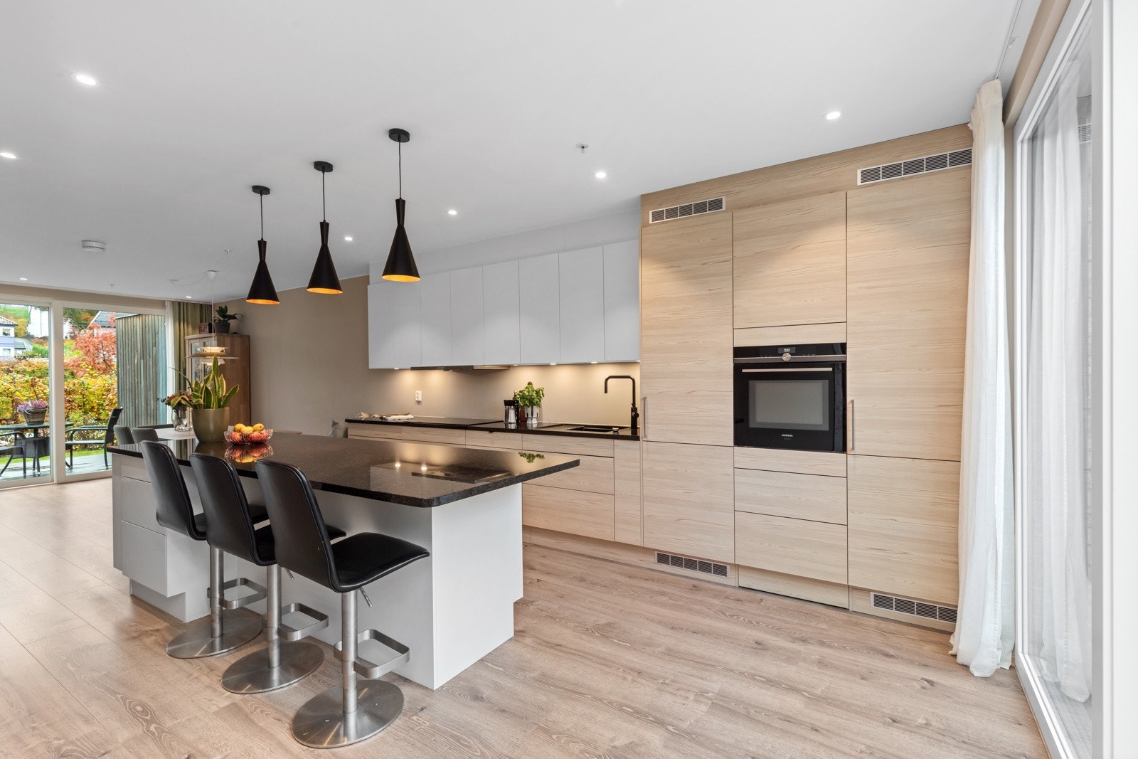 Stilrent kjøkken med integrerte hvitevarer og kjøkkenøy | Siemens helintegrerte hvitevarer: stekeovn, oppvaskmaskin, kombiskap og platetopp Galleribilde