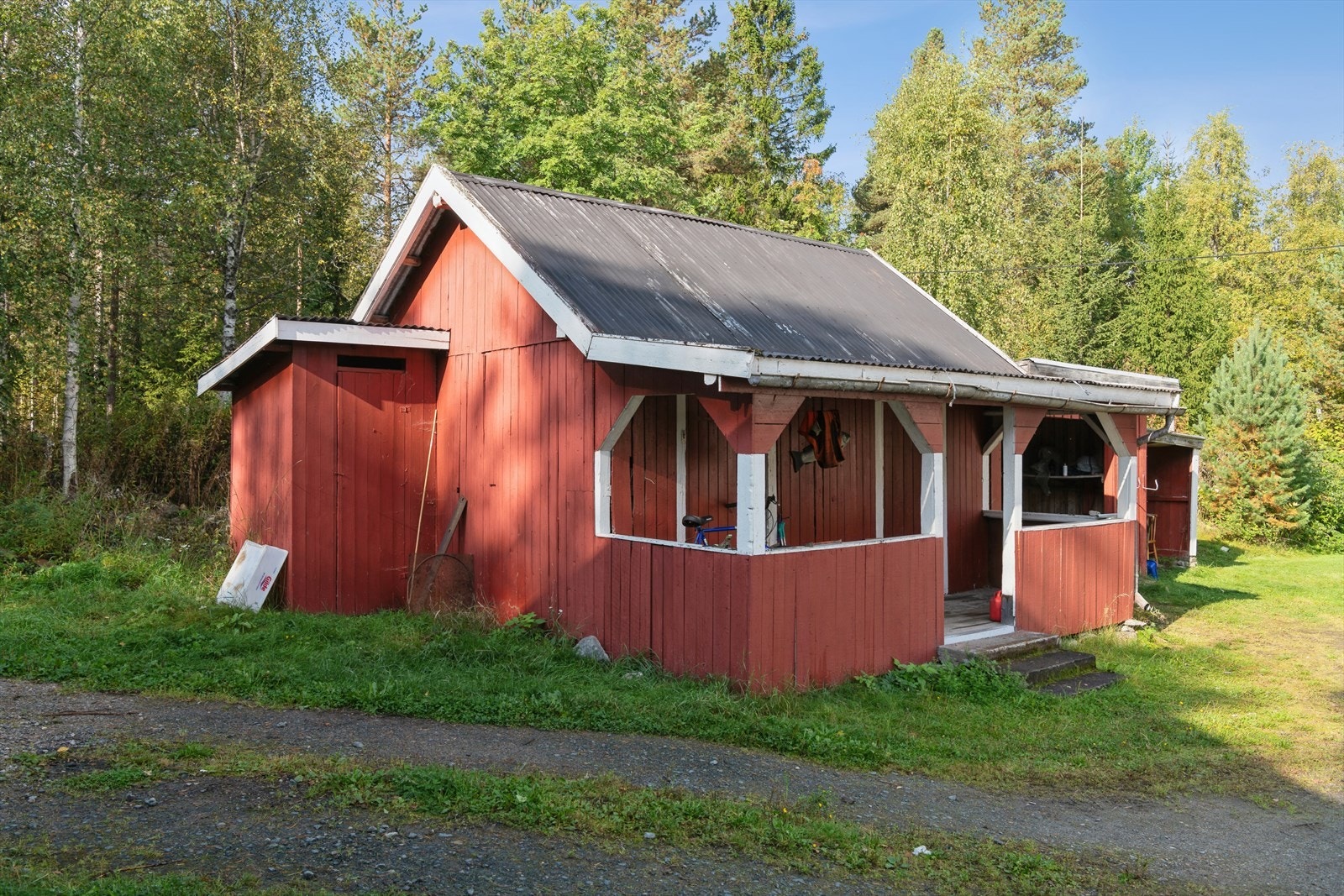 Eiendommen inkluderer et uthus med carport og gode lagringsmuligheter. Galleribilde