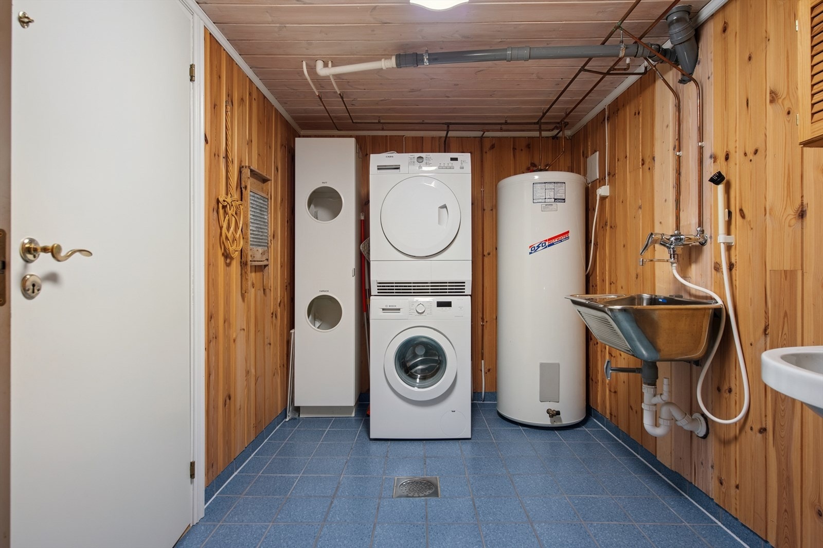 Vaskerommet er utstyrt med WC toalett, vegghengt servant og utslagsvask. Det er opplegg for vaskemaskin, og oppvarmingen skjer via gulvvarme i gulvet. Galleribilde