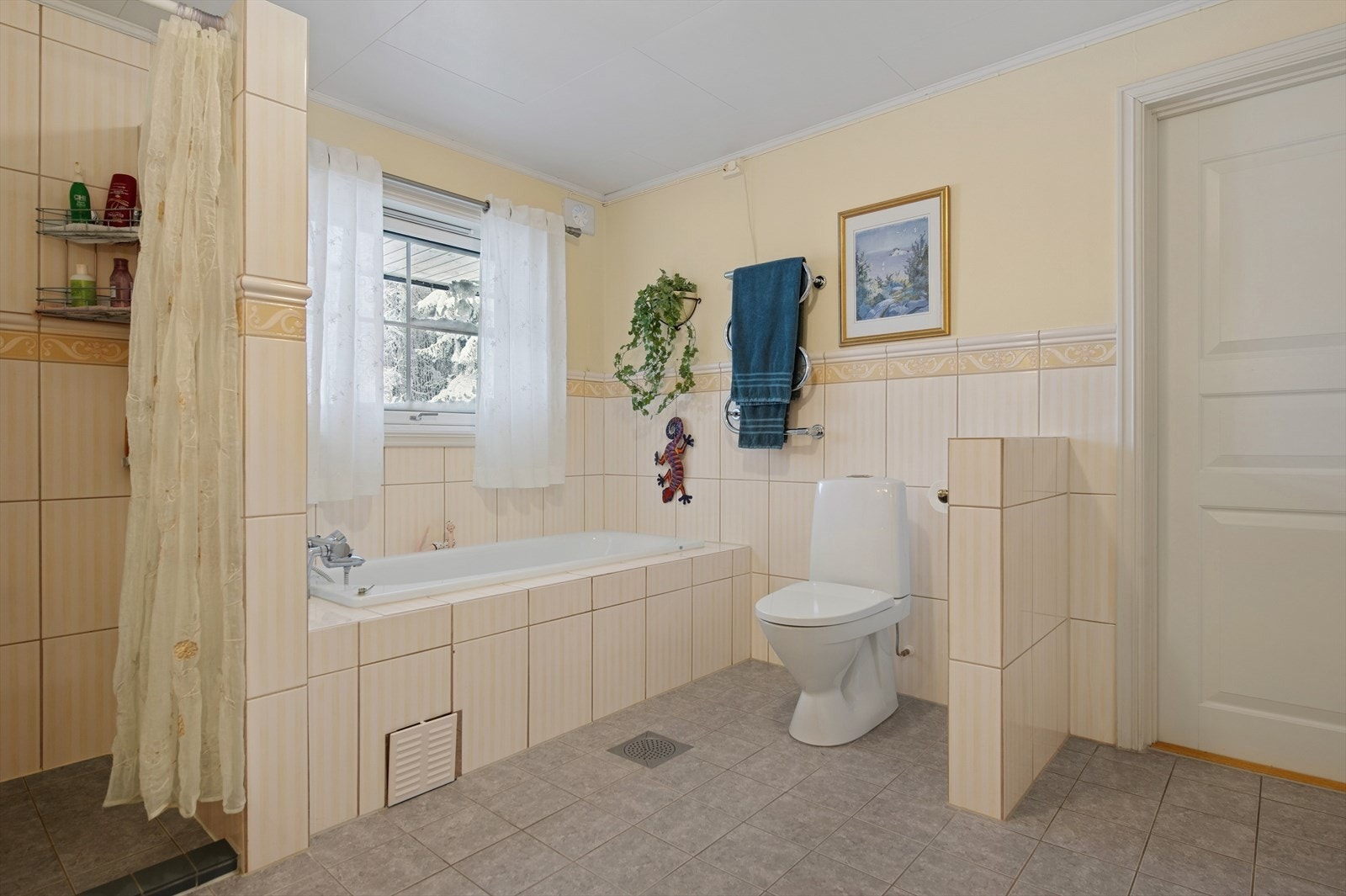 Baderommet er innredet med WC, dusjsone, badekar samt servant med skuffer og skap. Galleribilde