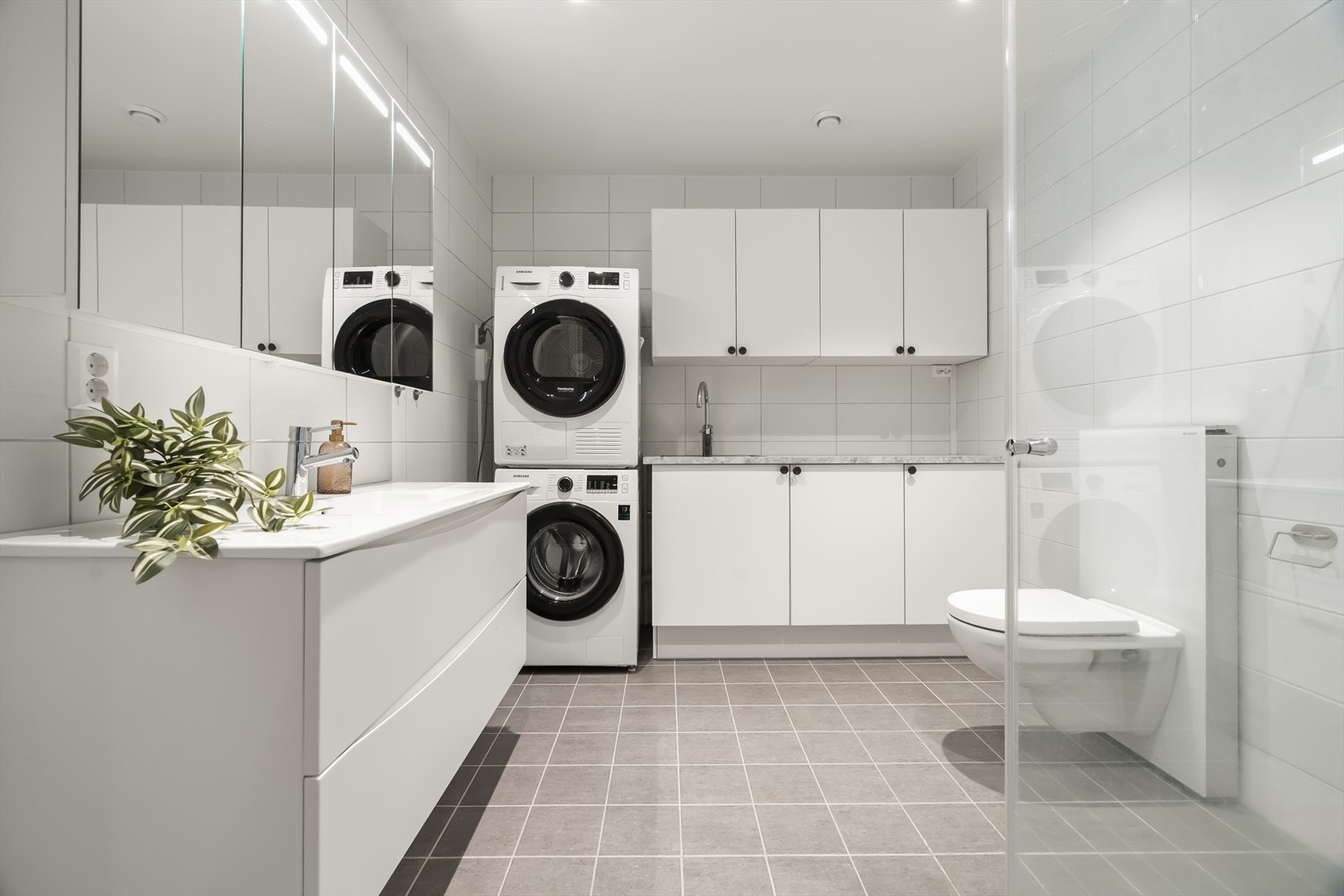 Praktisk vaskeromsløysing med vaskekum og skåp med eigen varmtvannsbereder på badet Galleribilde