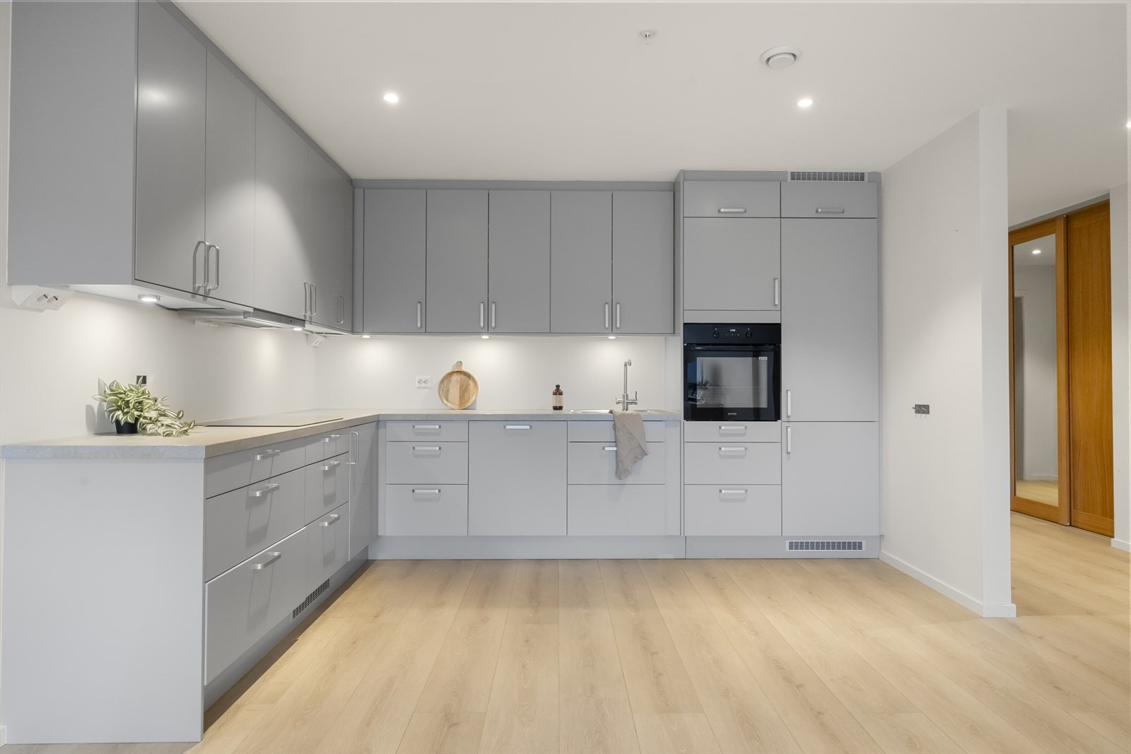 Eit stort kjøkken med integrerte kvitevarer Galleribilde