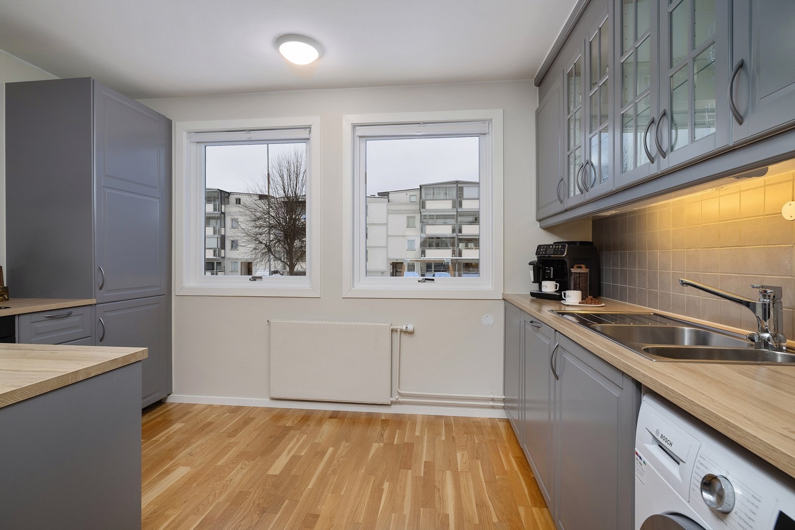 Moderne kjøkkeninnredning med profilerte fronter, laminat benkeplate og integrerte hvitevarer. Galleribilde