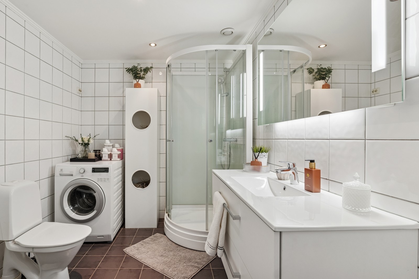 Flislagt bad med dusjkabinett, toalett og servant m/innredning. Opplegg for vaskemaskin Galleribilde