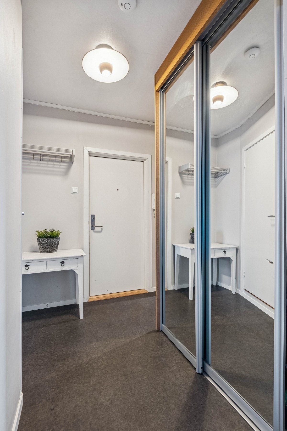 Romslig gang med praktisk skyvedørsgarderobe. Galleribilde