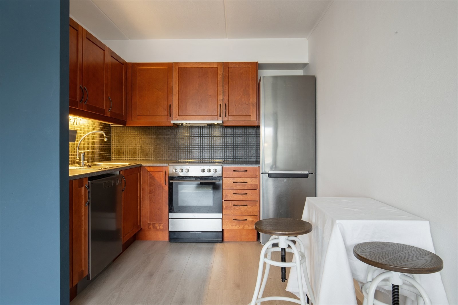 Kjøkkenet har glatte fronter, benkeplate i laminat og avtrekk koblet til bygningens sentrale avtrekksanlegg. Galleribilde