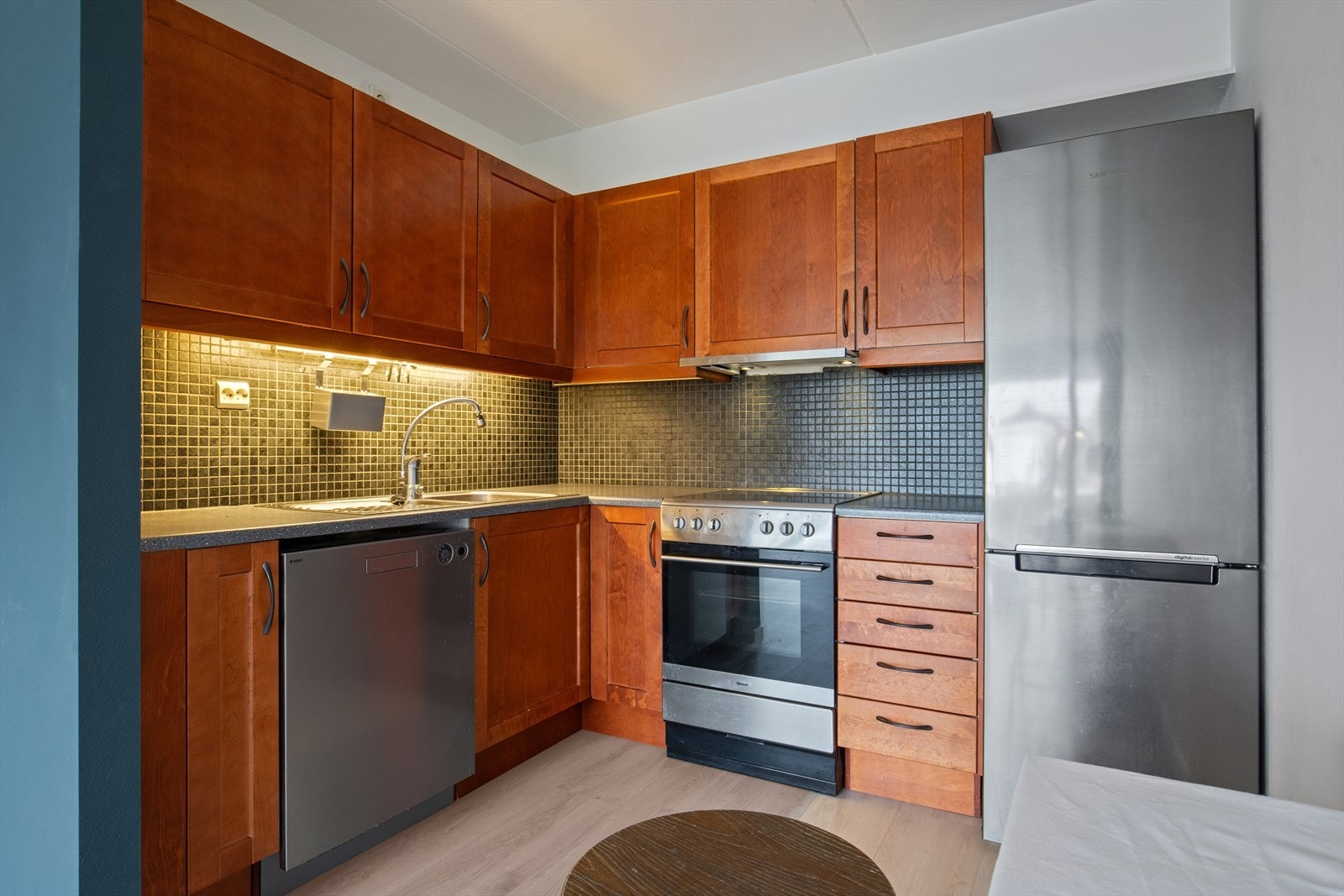 Det er registrert fuktskjolder og svelling i bunnplaten i benkeskapet, noe som kan være fint å ta med i vurderingen ved eventuell oppgradering. Galleribilde