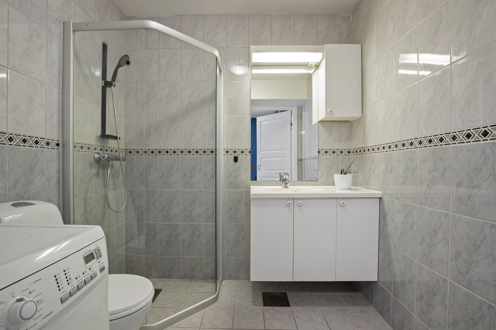 Badet er fra byggeår og har fliser på gulv og vegger, malt himling og vannbåren gulvvarme, samt mekanisk avtrekk. Det er innredet med servant nedfelt i skap, toalett, dusjhjørne og opplegg for vaskemaskin. Galleribilde