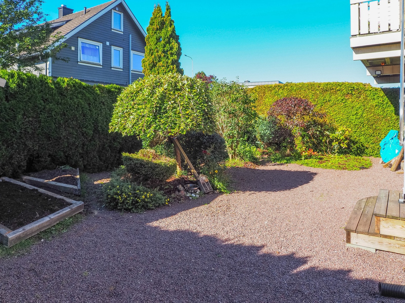 Sommerbilde av den skjermede hagen med god plass til utemøbler Galleribilde