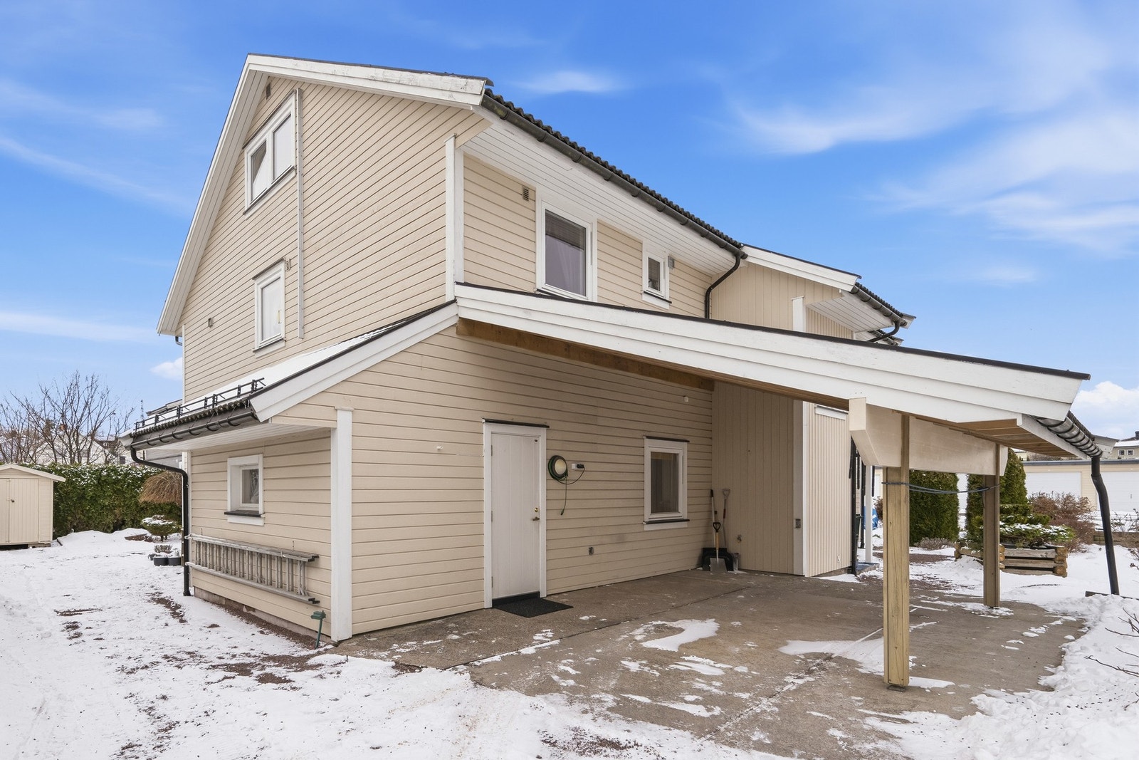 Her ser vi fasaden mot øst og syd med carport og "bakdøren" til 1. etasje Galleribilde