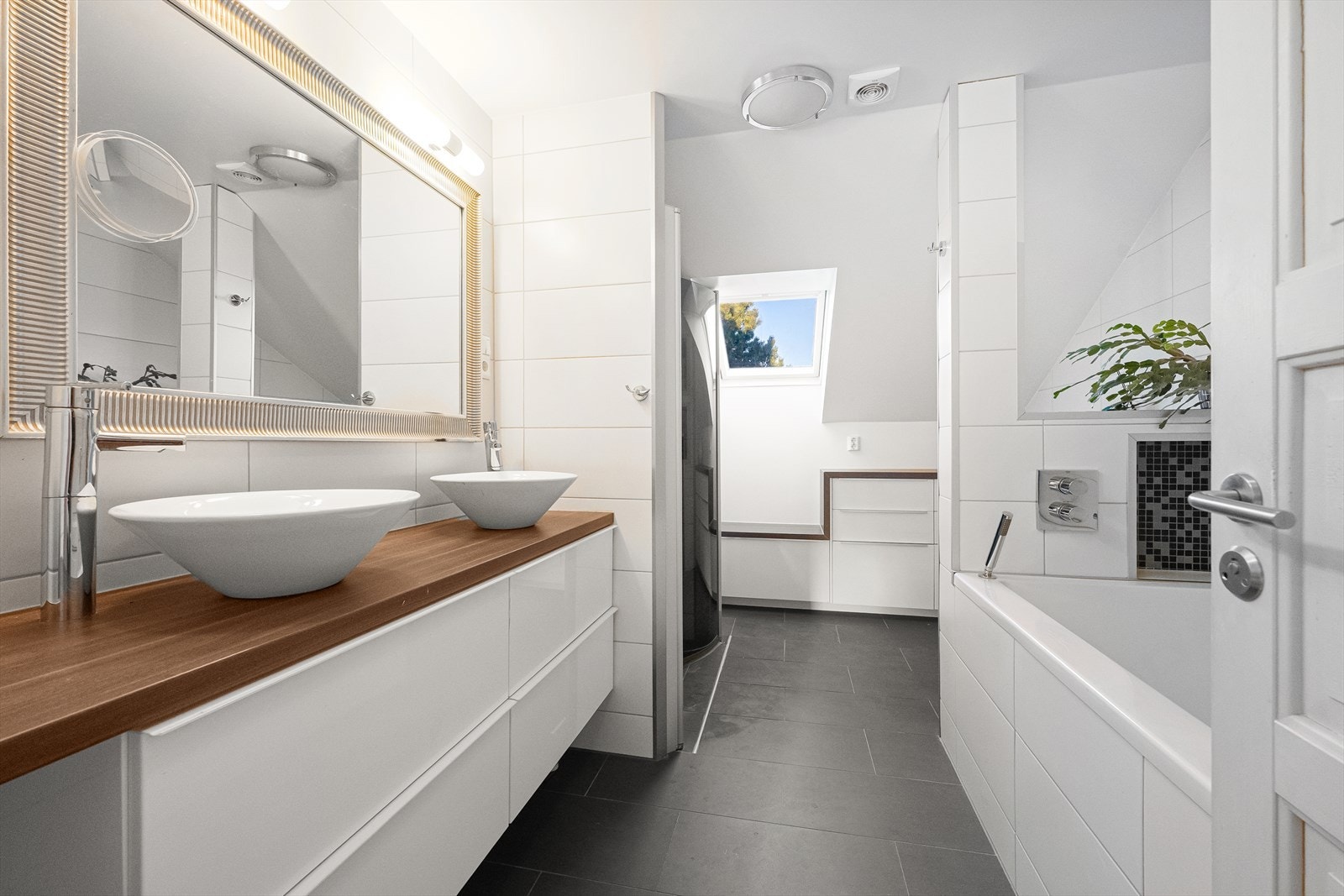 Fullfliset bad med dobbel servant, badekar, dusj og toalett. Galleribilde