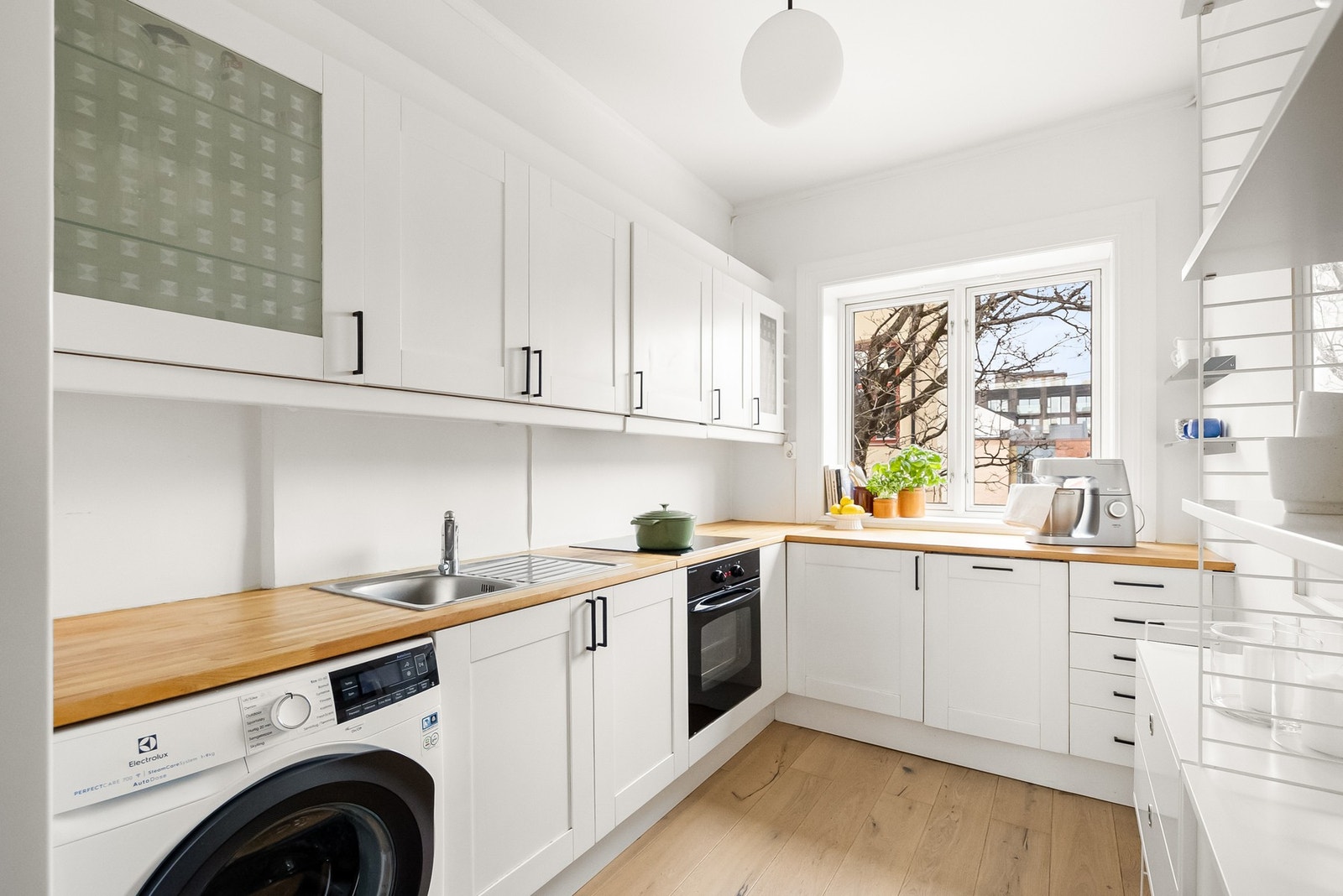 Kjøkken innredet med profilerte fronter og overskap med benkebelysning. Galleribilde