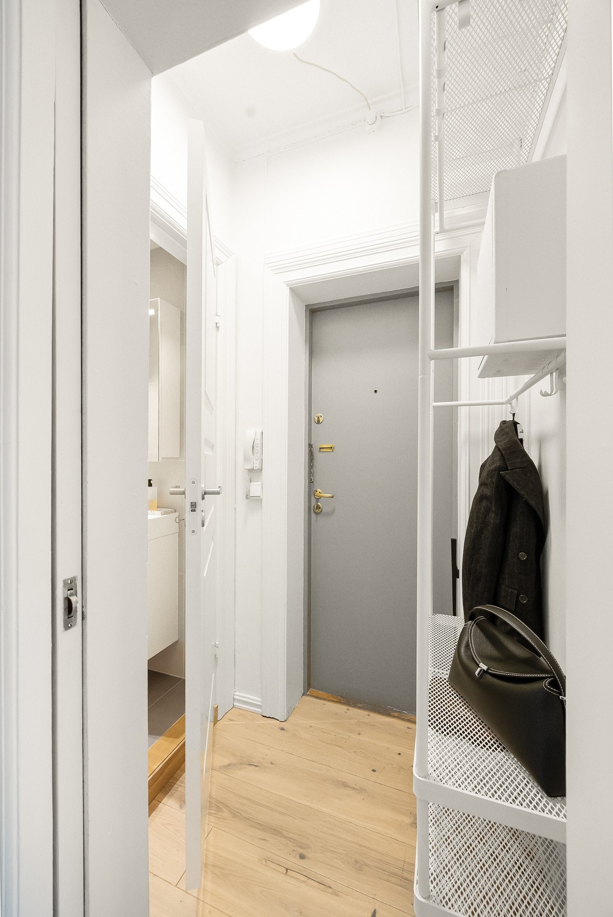 Innbydende inngangsparti med plass til oppheng av yttertøy og plassering av sko. Det er felles dørcallinganlegg med porttelefon. Galleribilde