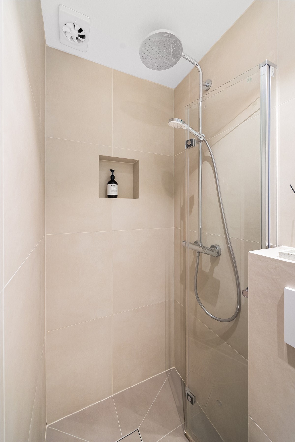 Det er innredet med innfellbar dusjvegg og termostatstyrt dusjbatteri i krom med både hånd- og regnfallsdusj. Galleribilde