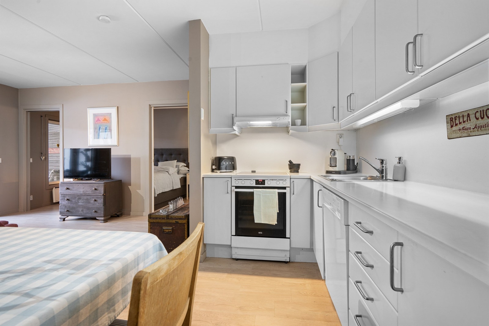 Nedfelt oppvaskkum av rustfritt stål med ett-greps armatur. Komfyr med keramisk platetopp. Galleribilde