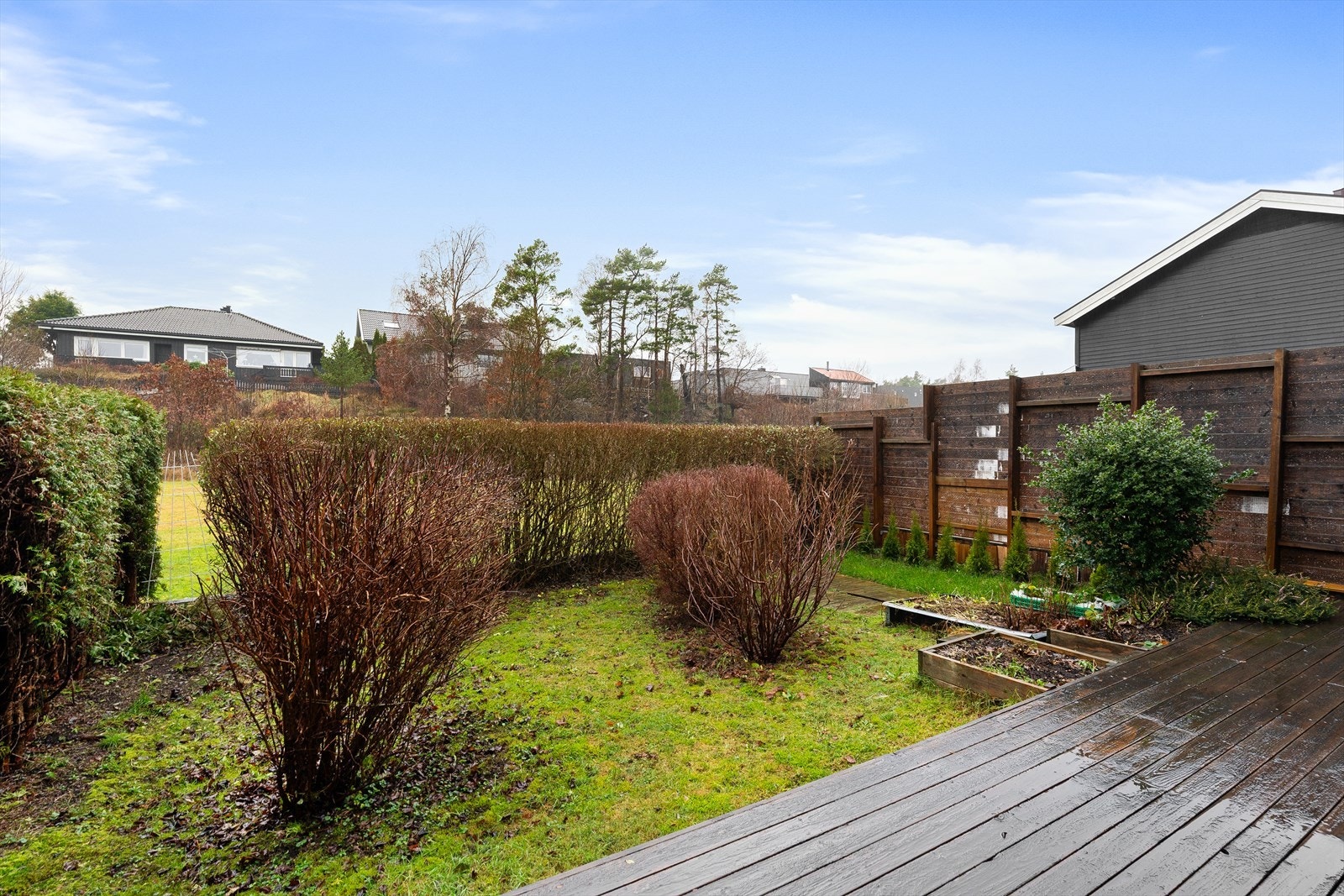 Hagen er opparbeidet med hekk, gressplen og annen beplantning. Legg merke til at det er et hull i hekken, perfekt om du har barn som vil leke på gresset og lekeplassen utenfor som er grøntareal eid av Kristiansand Kommune. Galleribilde
