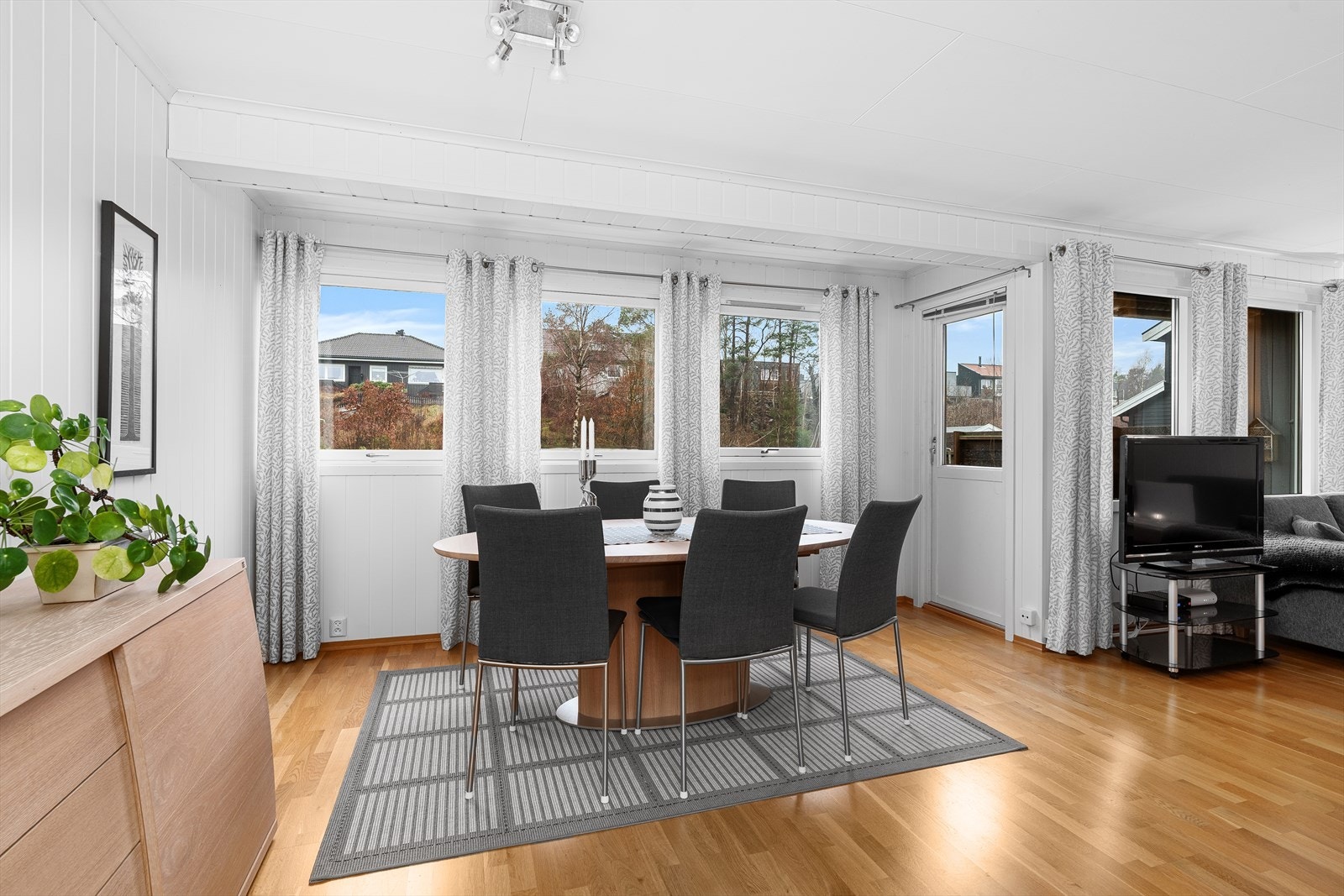 Legg merke til alle vindusflatene som sørger for rikelig med naturlig dagslys inn i rommet. Terrassedøren tar deg direkte ut til terrasse og hageområdet. Galleribilde