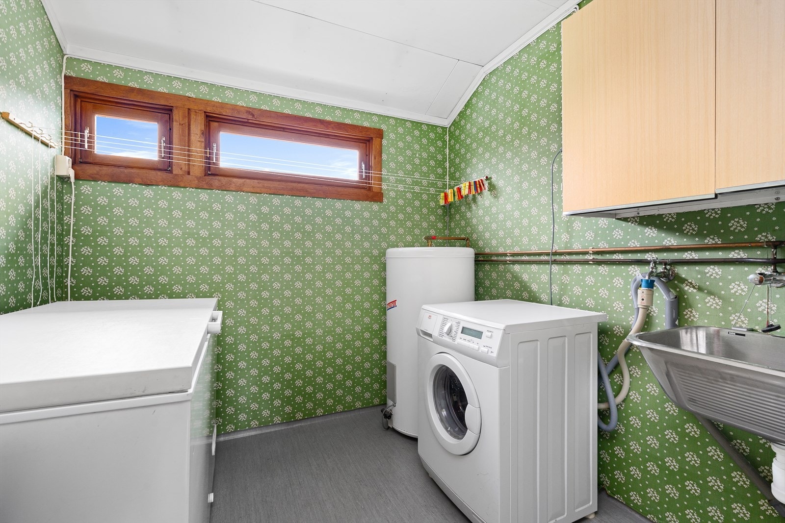 Vegg i vegg finner du vaskerommet som er av god størrelse. Her er det plass og opplegg for vaskemaskin, utslagsvask, varmtvannsbereder og plass til ekstra fryser, samt annen oppbevaring i veggskap. Galleribilde